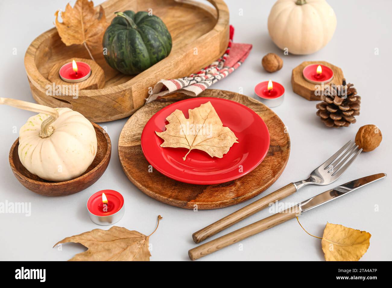Autumn table setting with pumpkins, dried leaves and burning candles on ...