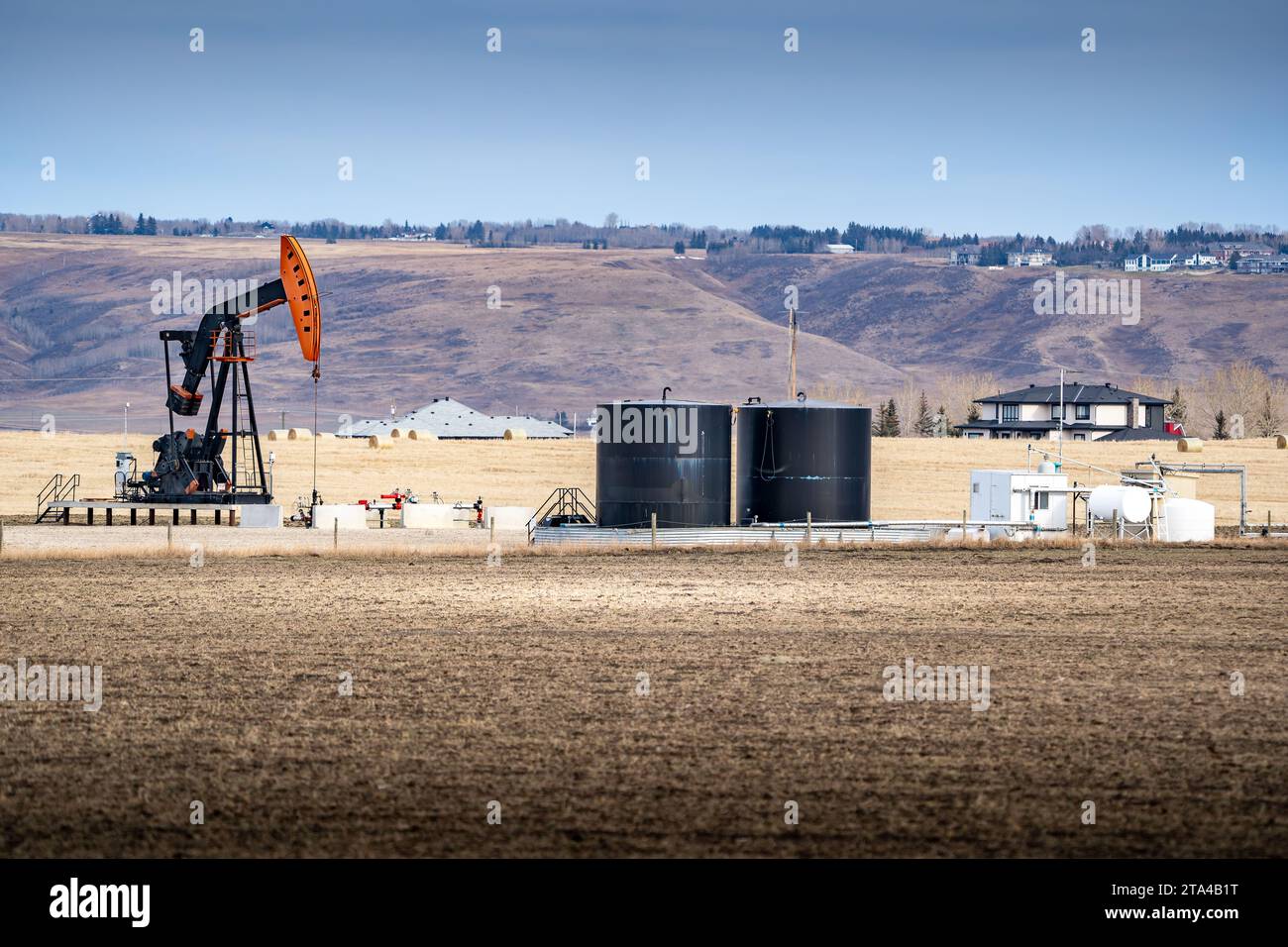 Pump jack working on a rural property for the oil and gas industry at Springbank Rocky View County Alberta Canada. Stock Photo