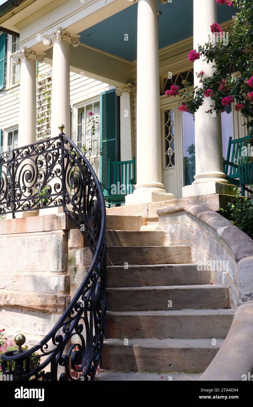 Mansion Front Porch and Spiral Staircase with Decorative Design Wrought Iron Railing Stock Photo