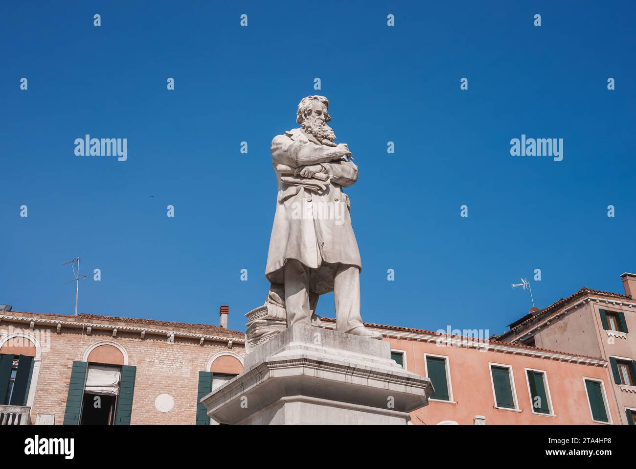 Venice Statue of Man in Long Coat and Hat Standing in Front of Historic ...