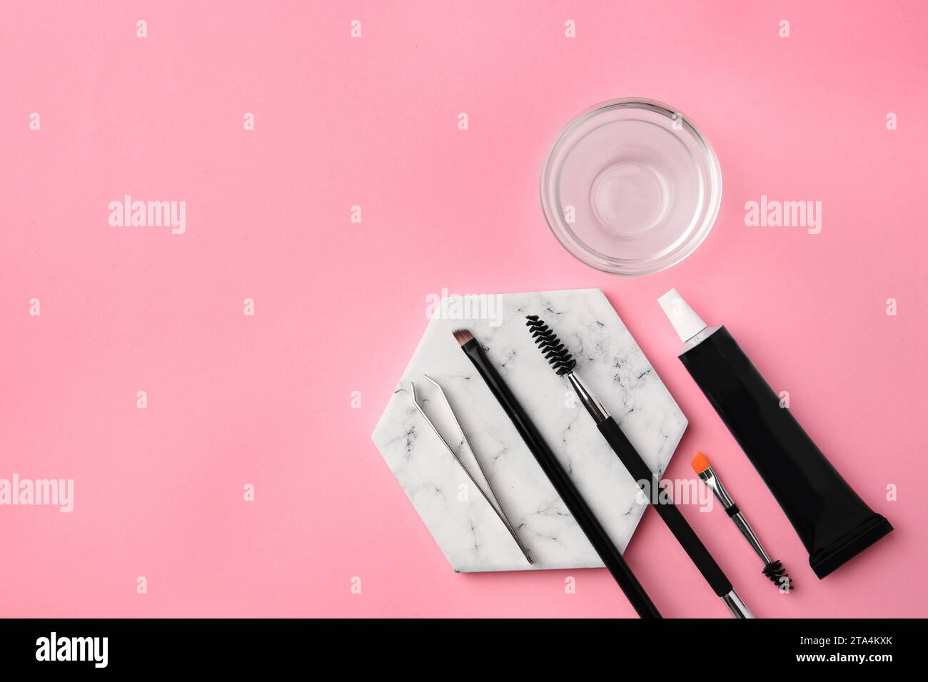 Flat lay composition with eyebrow henna and tools on pink background. Space for text Stock Photo
