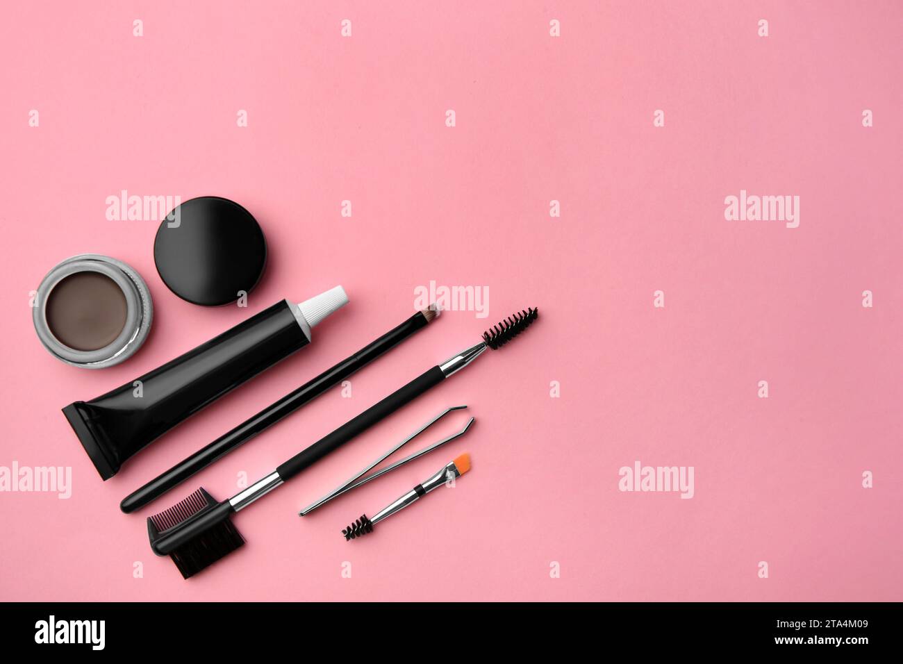 Flat lay composition with eyebrow henna and tools on pink background. Space for text Stock Photo