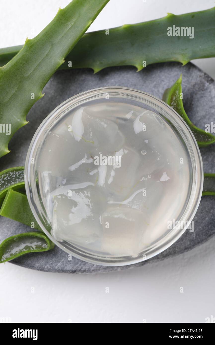 Aloe vera gel and slices of plant on white background, top view Stock — free download