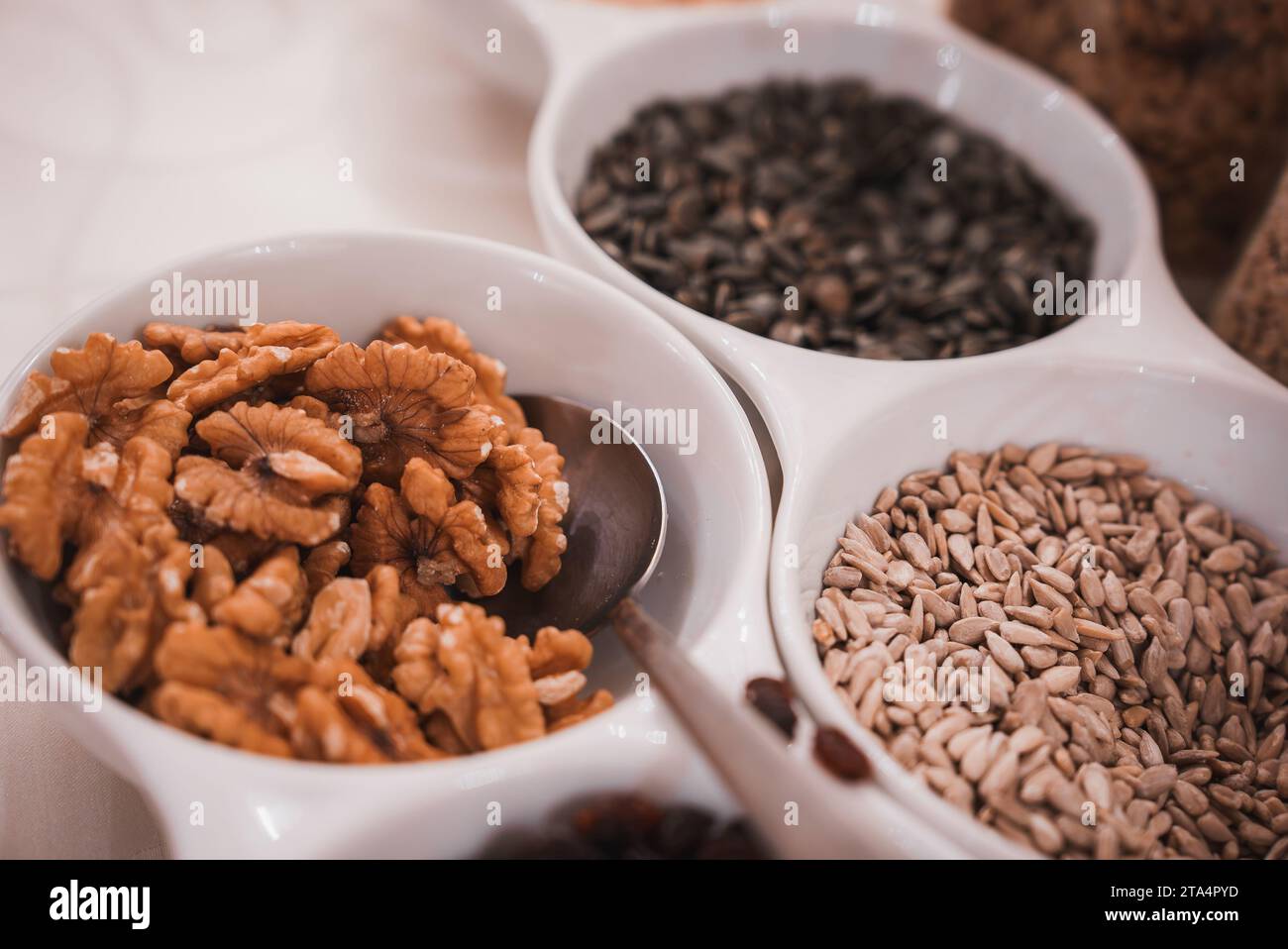 Assorted nuts and seeds in bowl on table in dim lighting, Venetian hotel interior. Stock Photo
