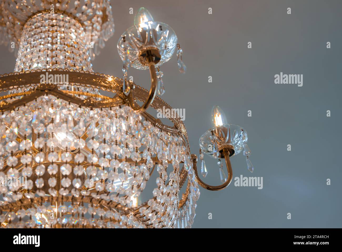 An elegant gold chandelier with crystals illuminates a luxurious room, adding sophistication and