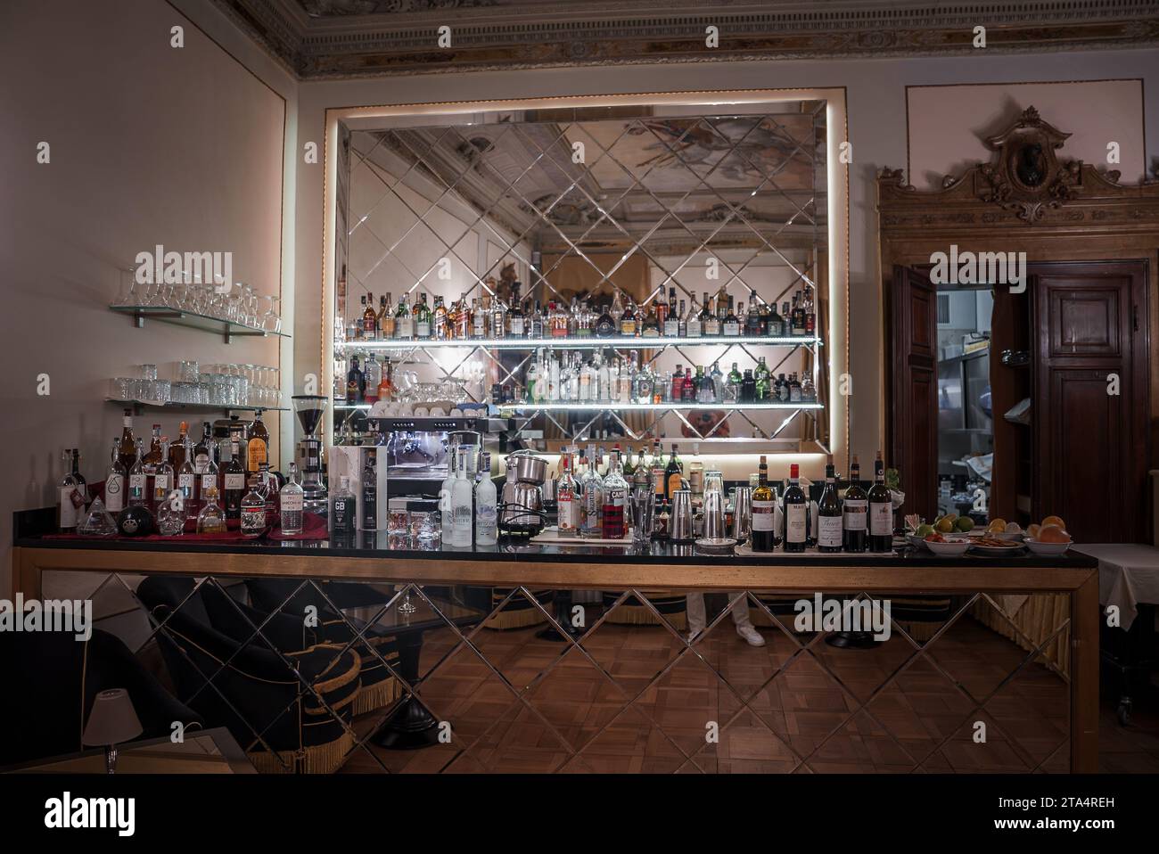 Dark and Moody Bar Interior with Large Mirror, Bottles, and Glasses in ...