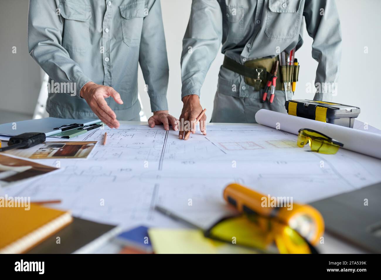 Cropped image of civil engineer and architect discussing details of blueprint Stock Photo