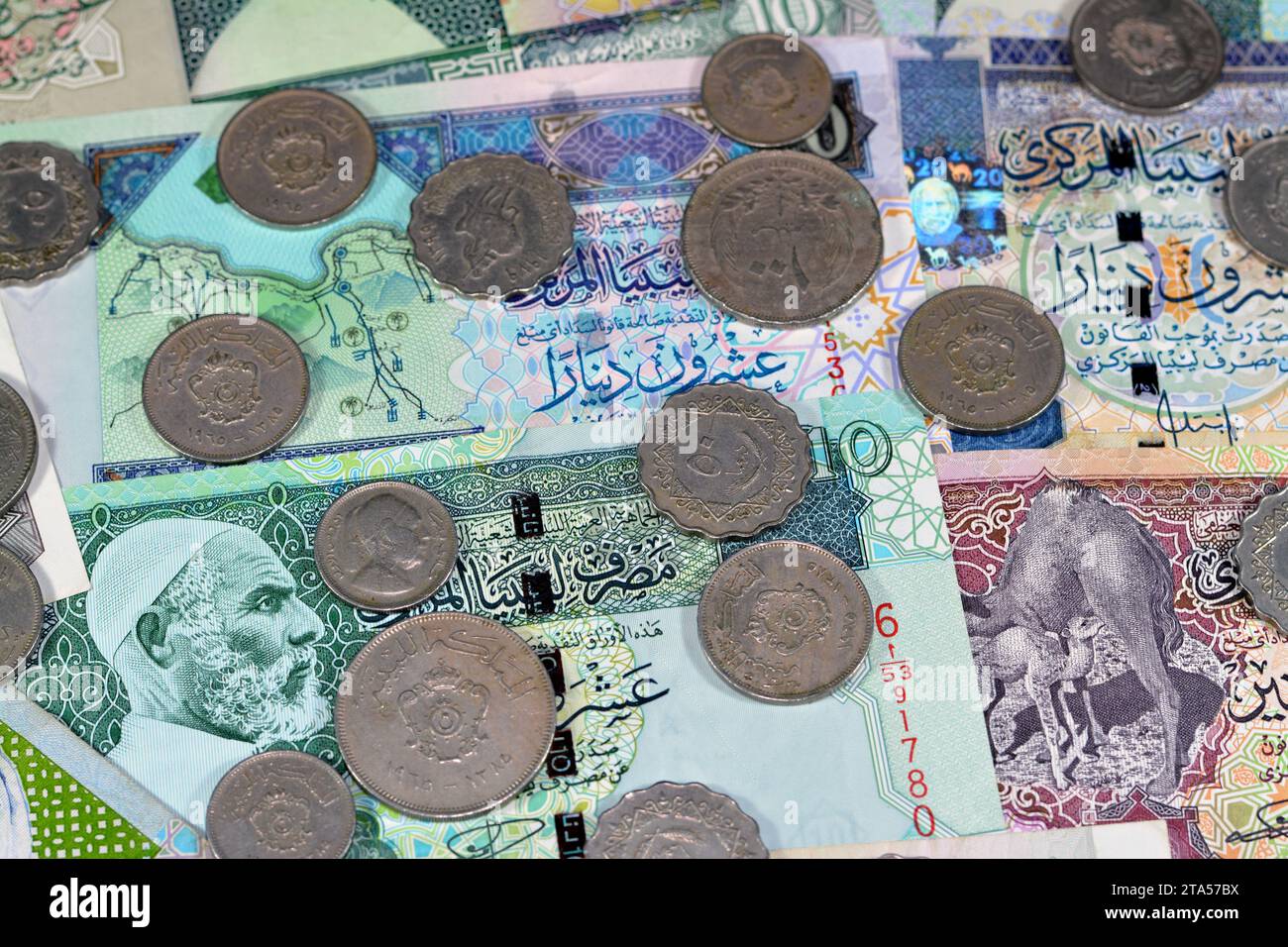 Background of old Libyan money banknote bills and coins of different eras from the kingdom to Jamahiriya of Libya times, vintage retro old Libyan curr Stock Photo