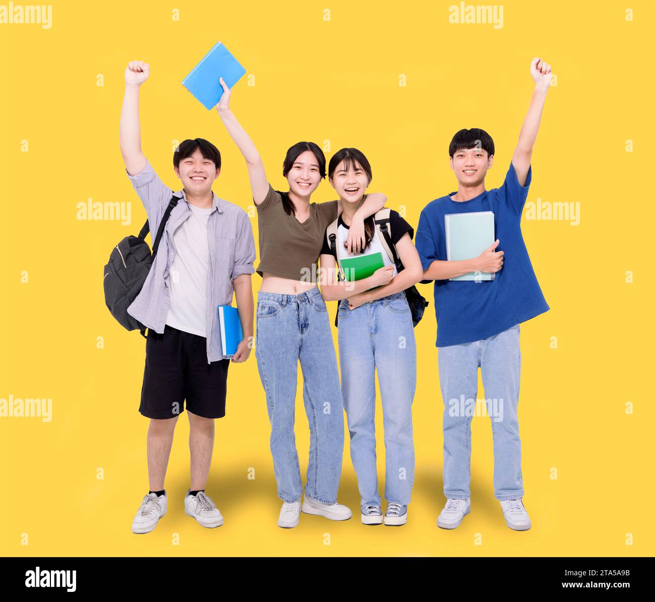 Full length of stylish teenager students on yellow background Stock Photo
