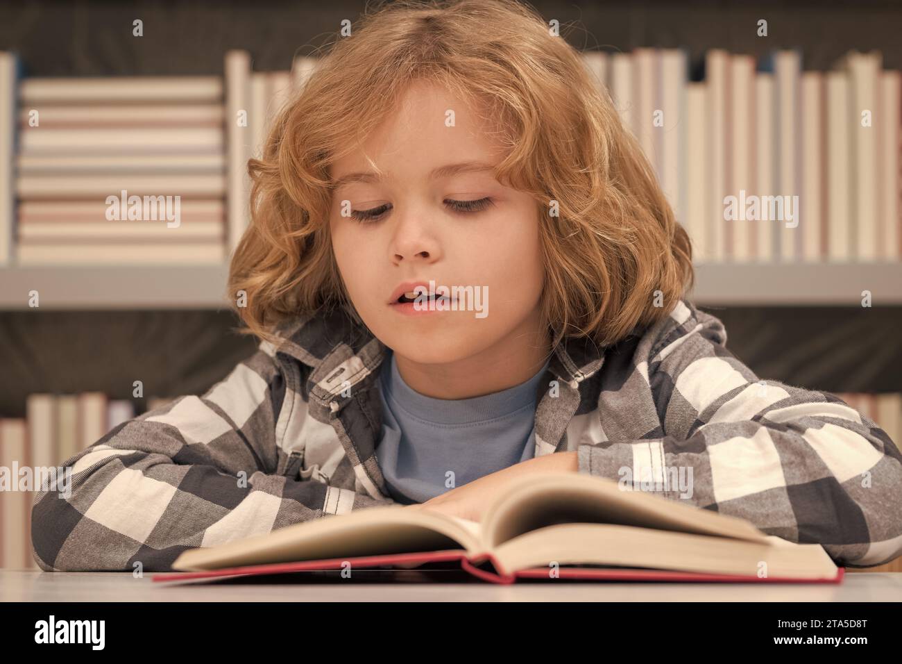 Kid reading book in a book store or library Stock Photo