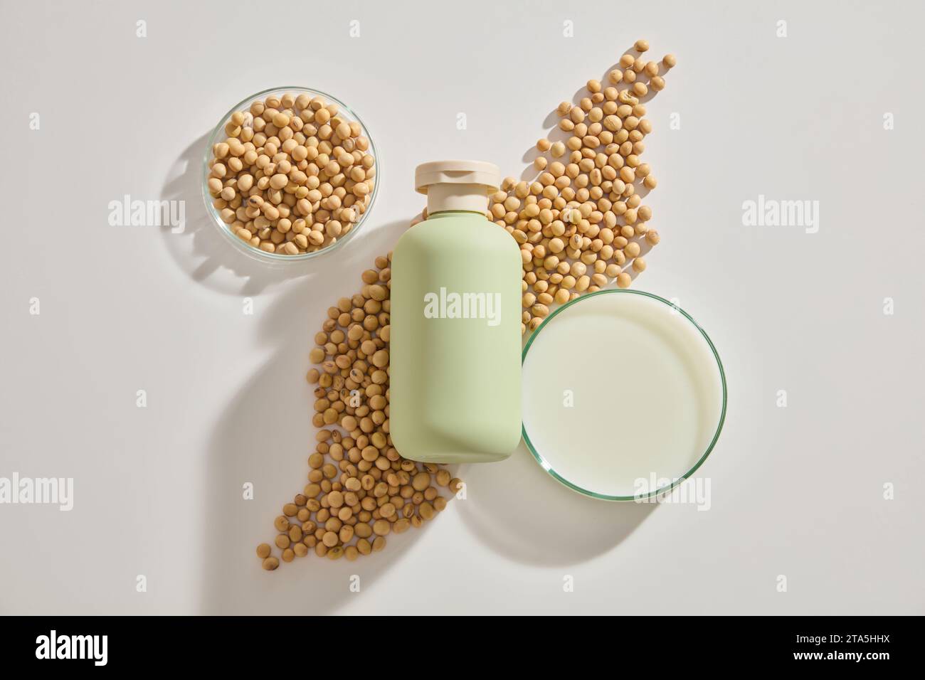 Cosmetic bottle without label placed on a heap of soybeans, displayed