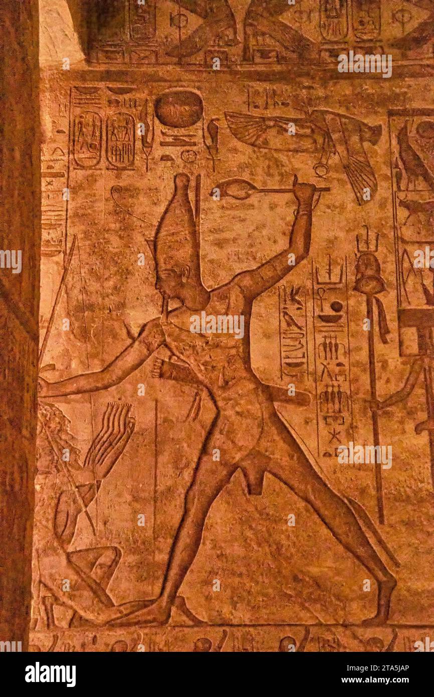 The engraving of Egyptian figures next to hieroglyphs inside the temple