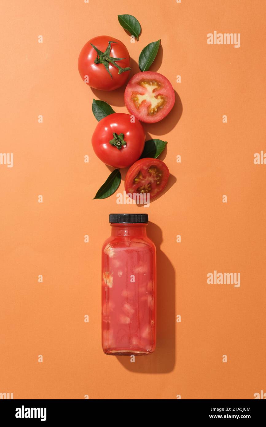 Empty label glass bottle of tomato juice decorated with red tomatoes