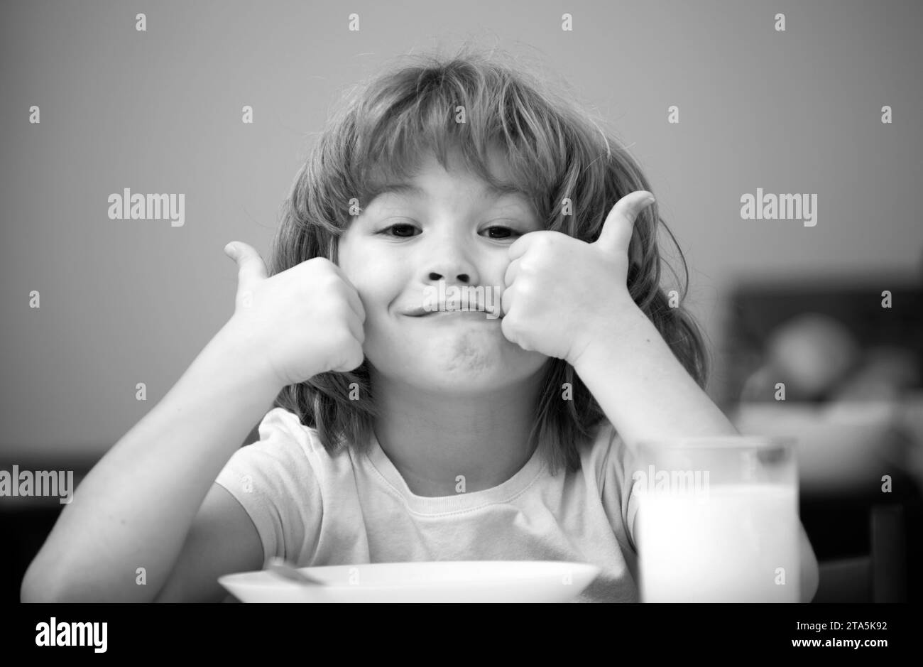 Portrait of cute child eating soup meal or breakfast having lunch by