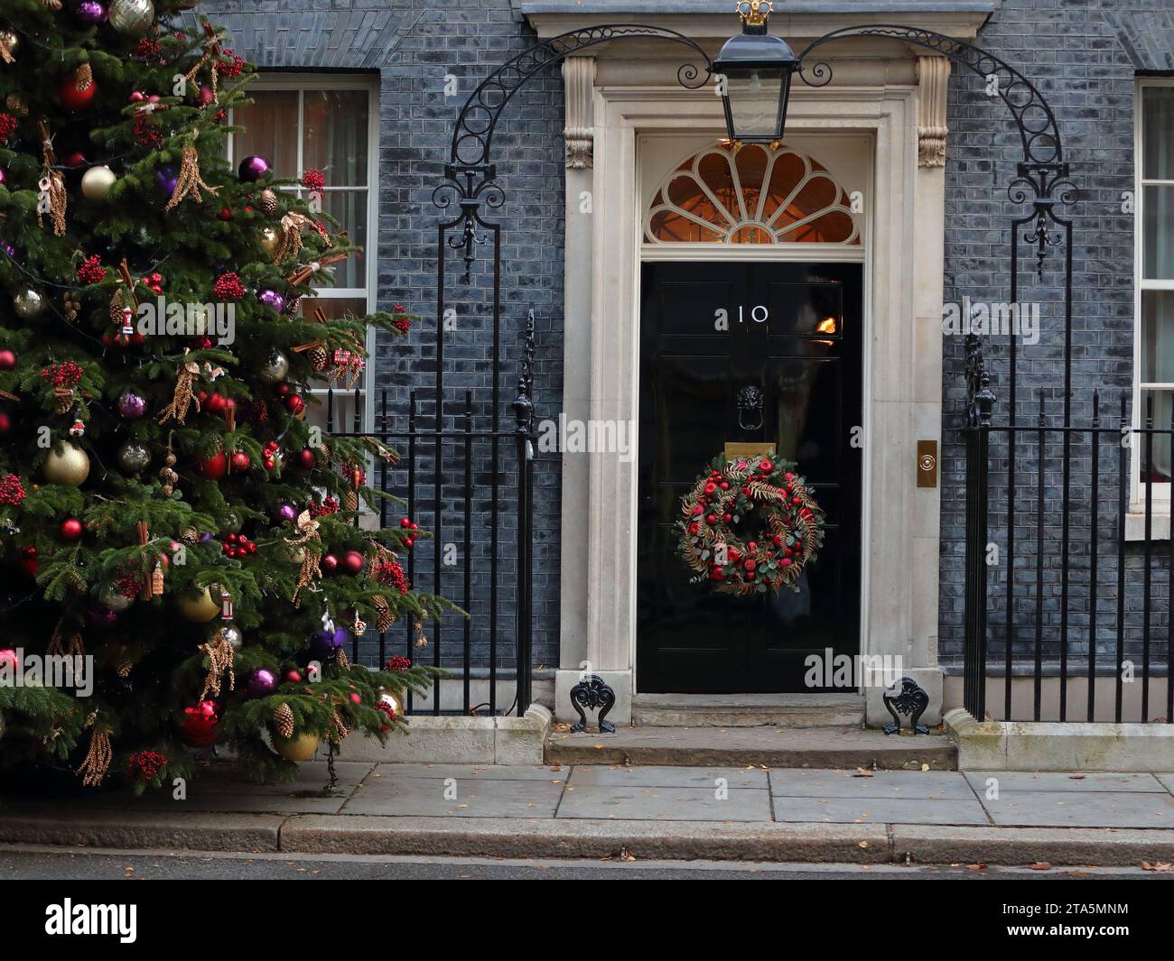 London, United Kingdom. 28th Nov, 2023. The entrance to No 10 Downing Street is decorated with a traditional Christmas tree and a wreath on the door. Stock Photo