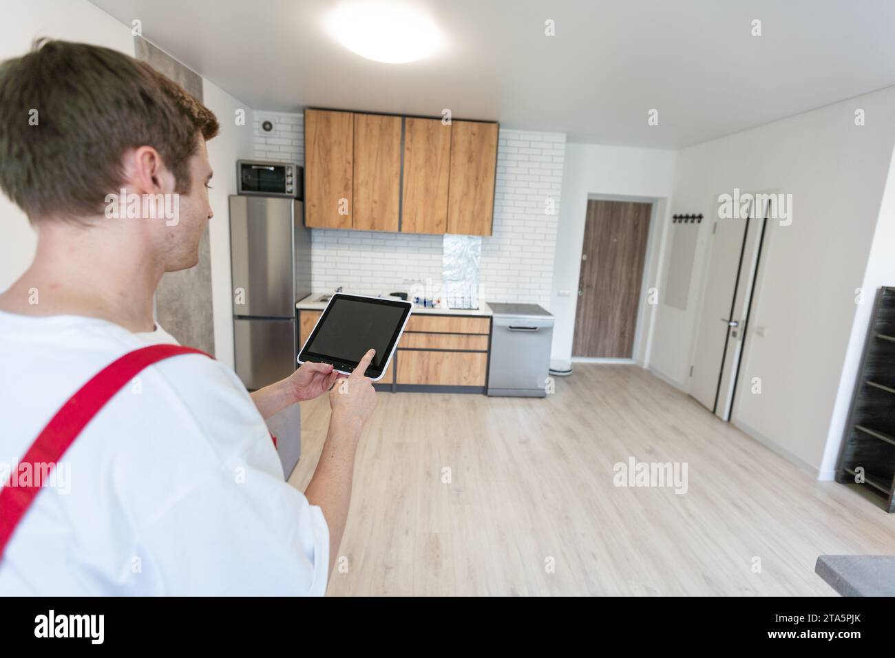 Worker with tablet computer checking alarm system indoors. Stock Photo