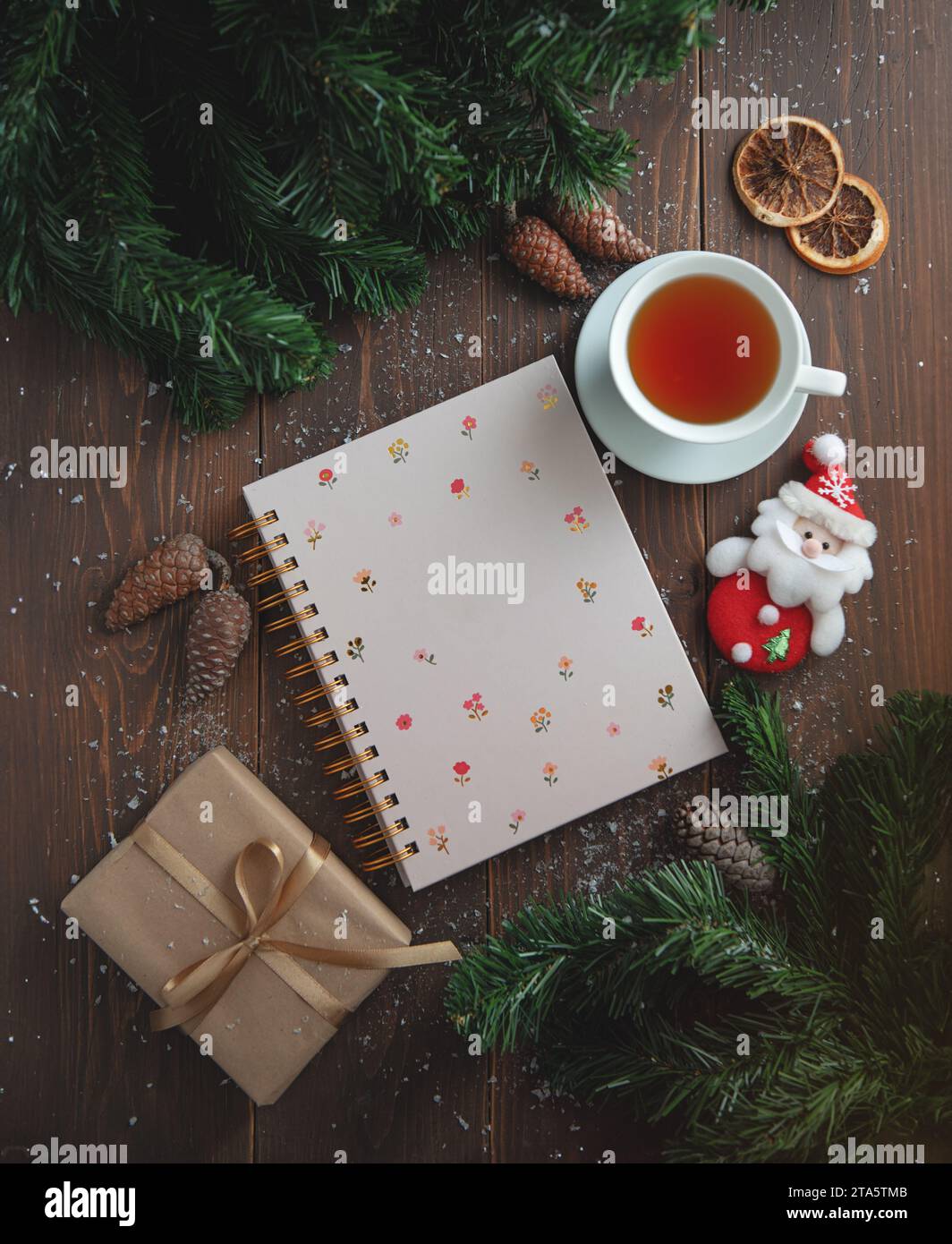 A beautiful composition with a notebook, cups of tea, on a wooden table. Stock Photo