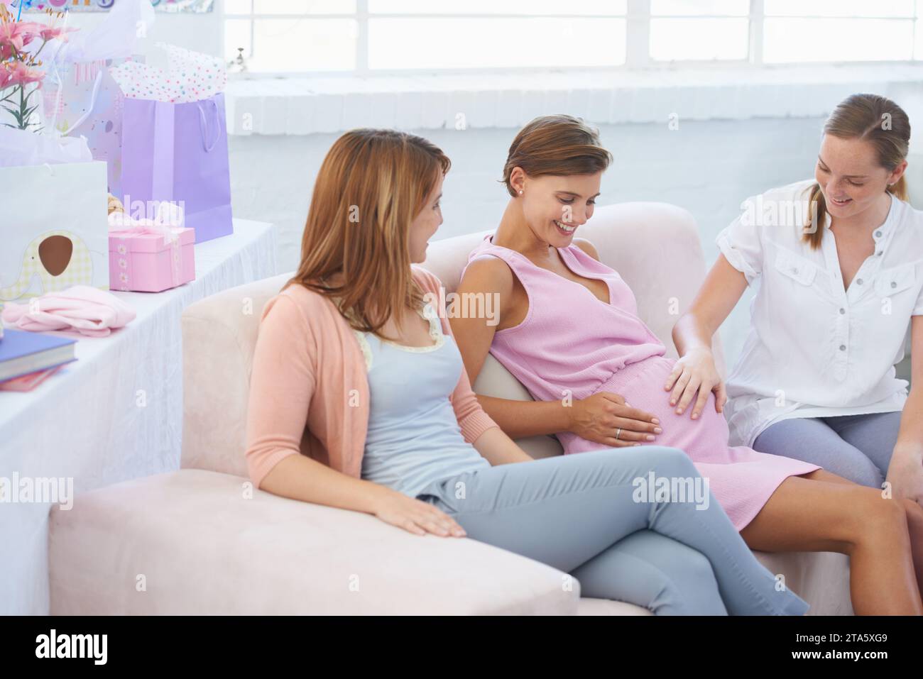 Women, baby shower and hand on stomach, living room couch and happy with fetus moving. Pregnant