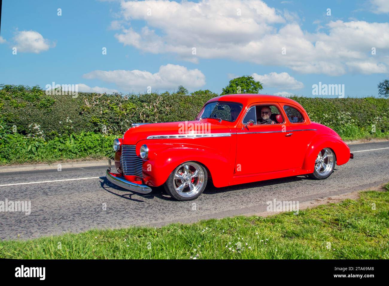 1940 40s forties Red American Chevrolet GMC.  Large USA 5700 cc petrol-powered yesteryear saloon car; Vintage, restored classic motors, automobile collectors motoring enthusiasts, historic veteran cars travelling in Cheshire, UK Stock Photo