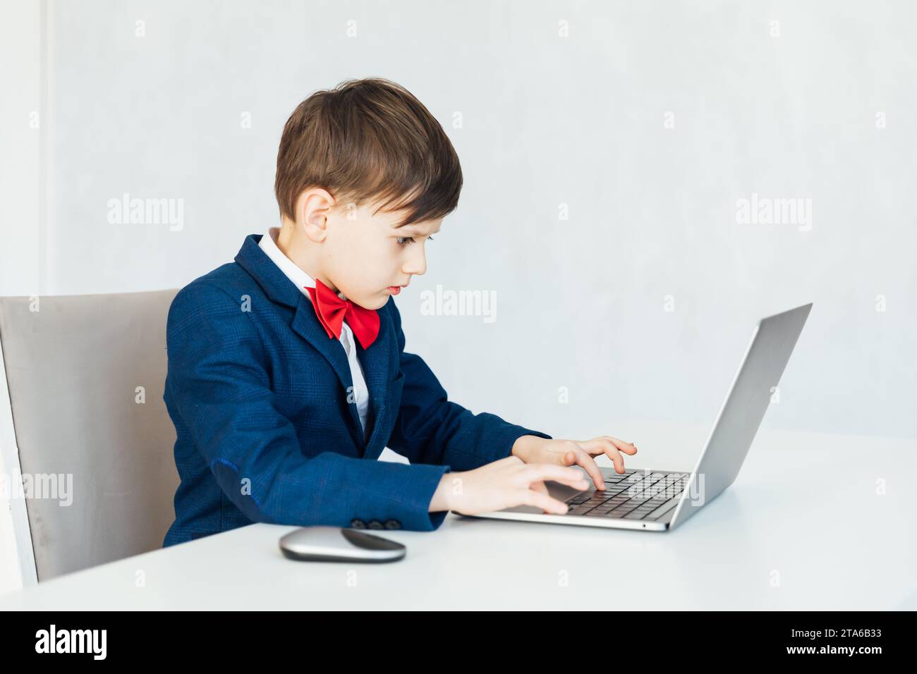Little boy using laptop on white background Stock Photo - Alamy