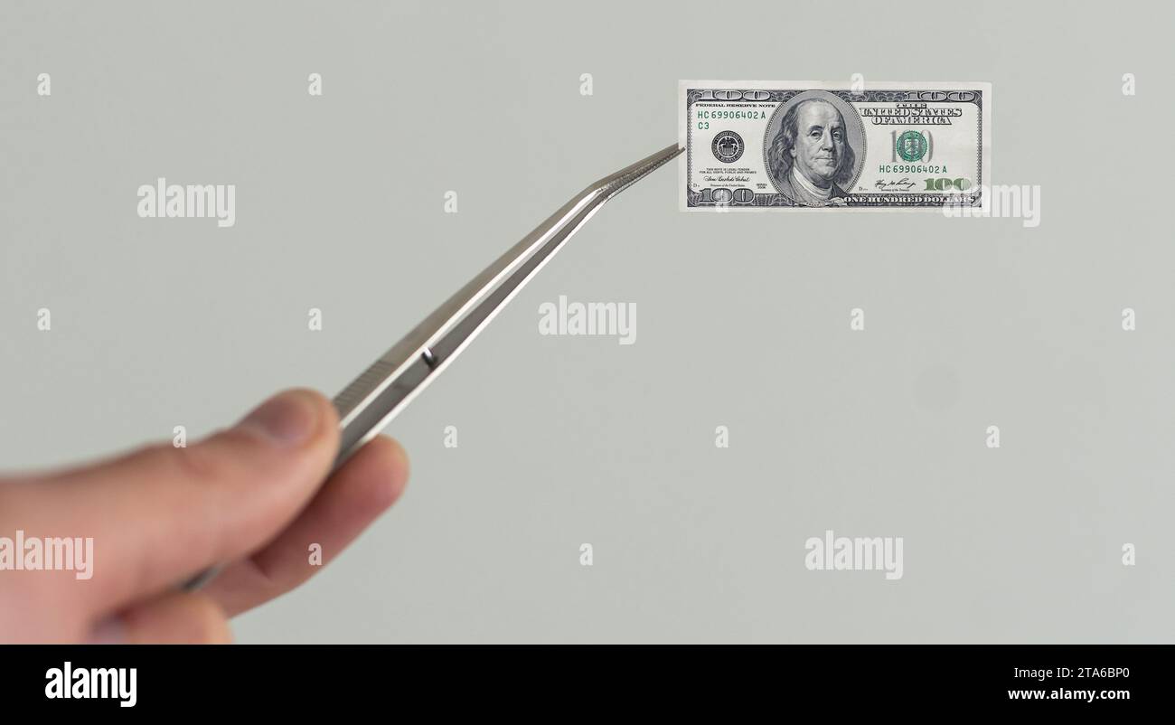 Money, dollar bill in tweezers Stock Photo Alamy