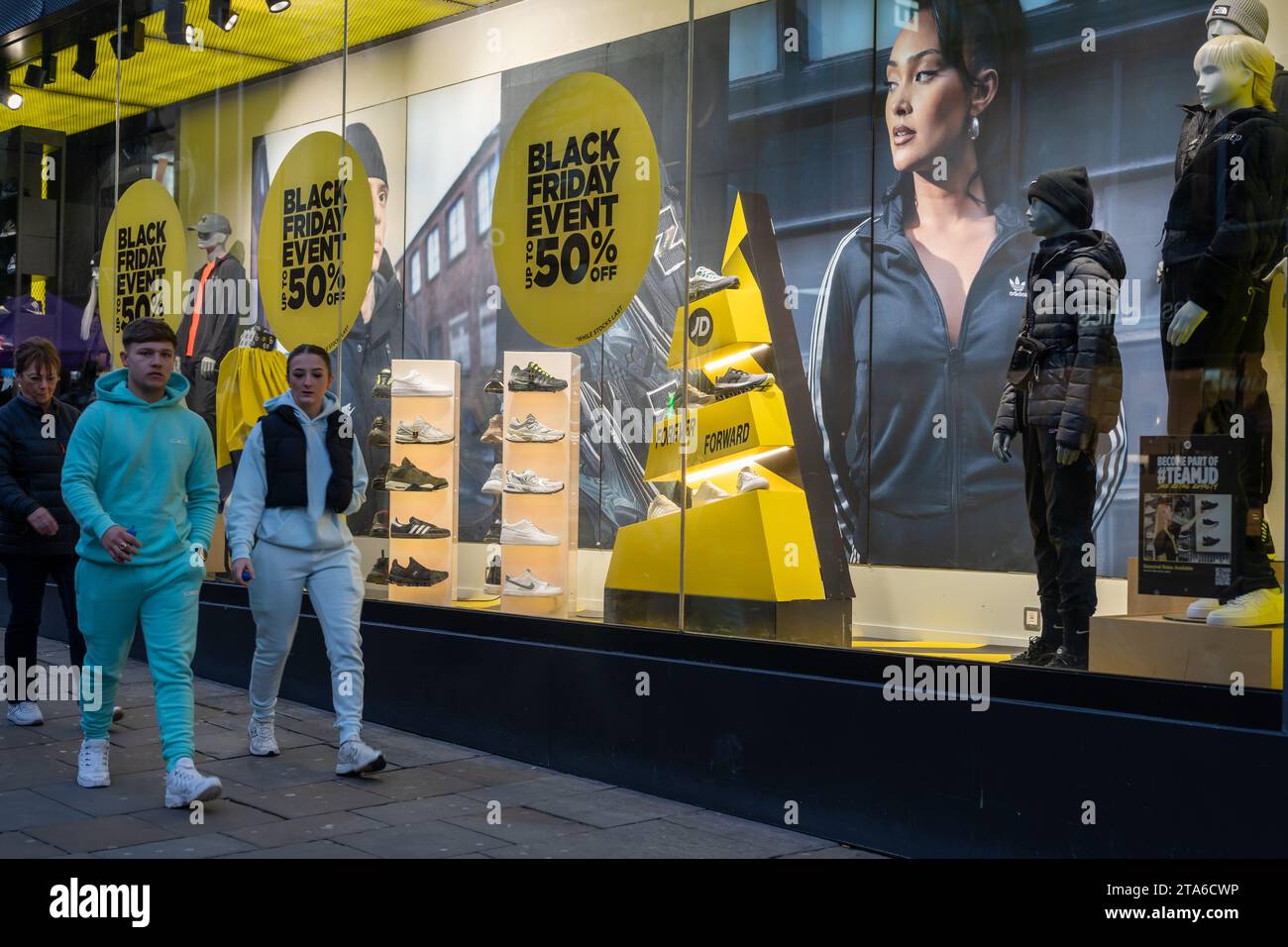 Shoppers walk past JD Sports window in Newcastle upon Tyne, UK on Black Friday. Concept of retail and economy. Stock Photo