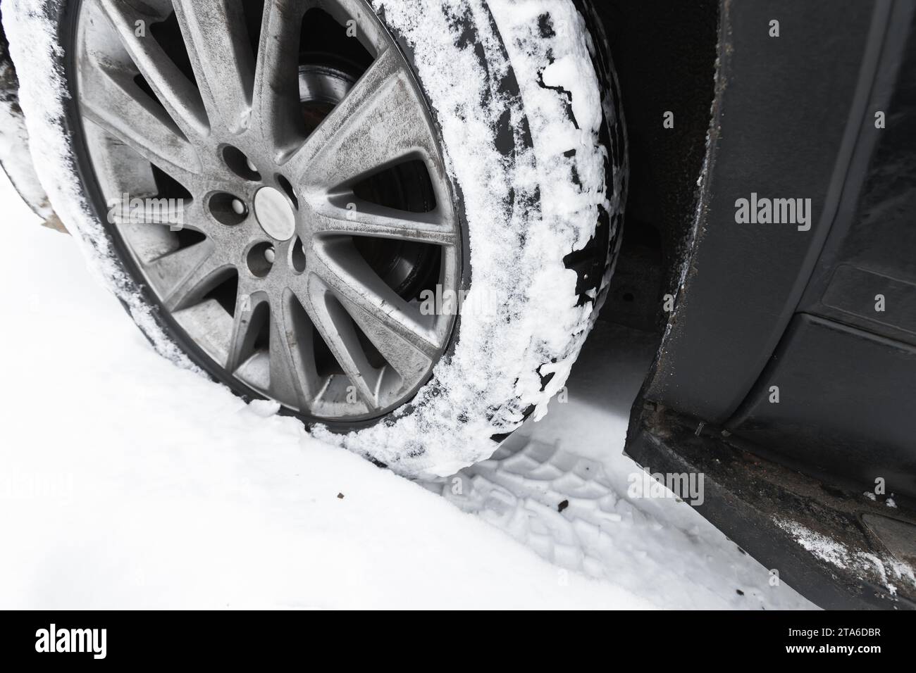 A car wheel on snow tire with metal studs. Close-up photo with selective focus Stock Photo