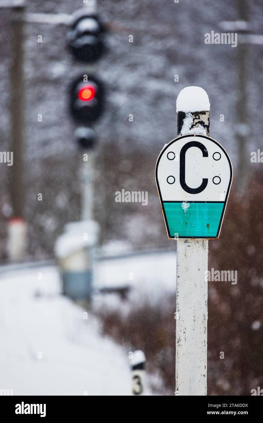 Russian railway Sign C - sound signal, semaphore shows red stop signal on a background. Vertical photo taken on a snowy winter day Stock Photo