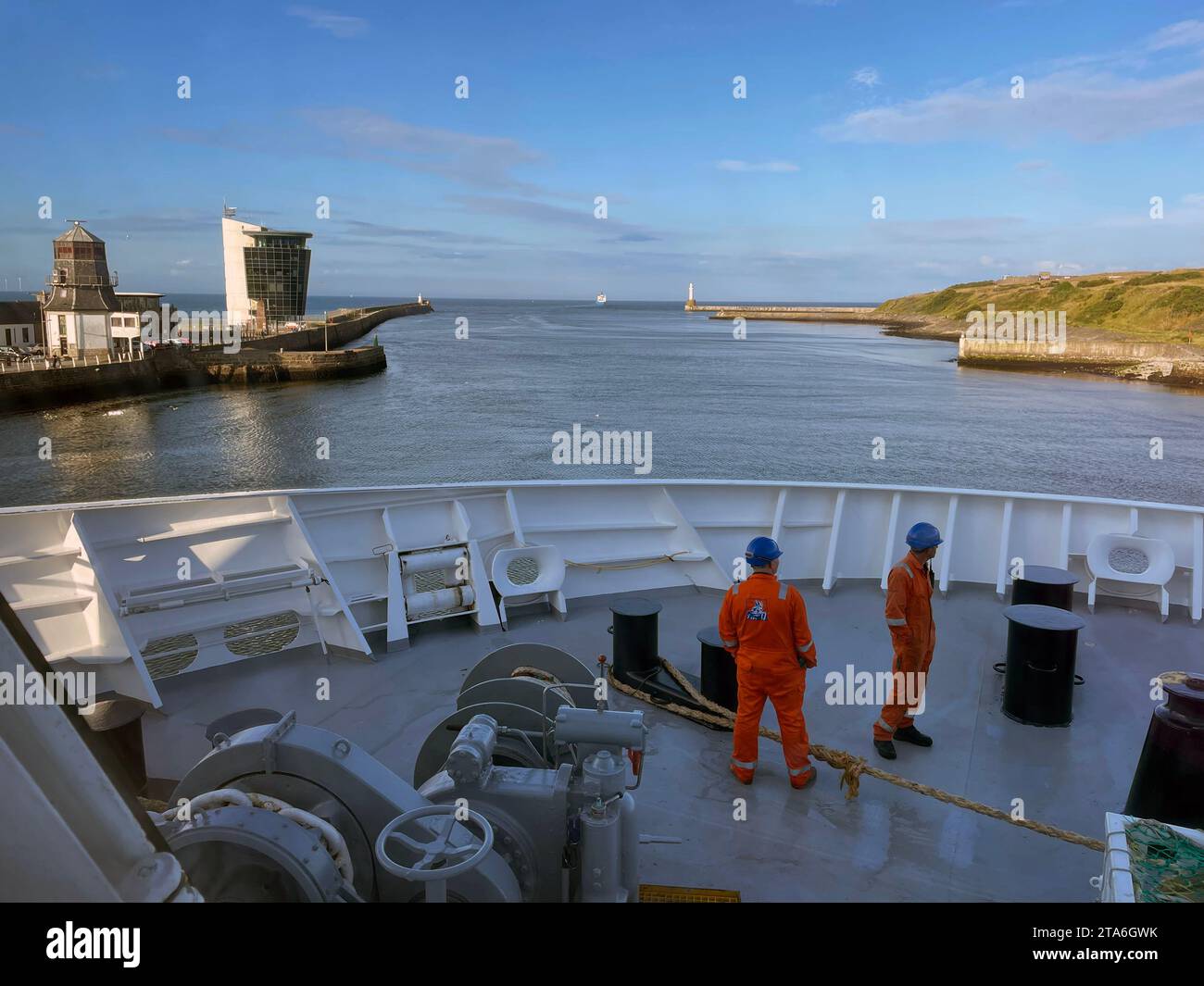 Sailing out of the Aberdeen harbour in Scotland in the early evening on the North Link ferry bound for the Shetland islands with engineers on deck Stock Photo