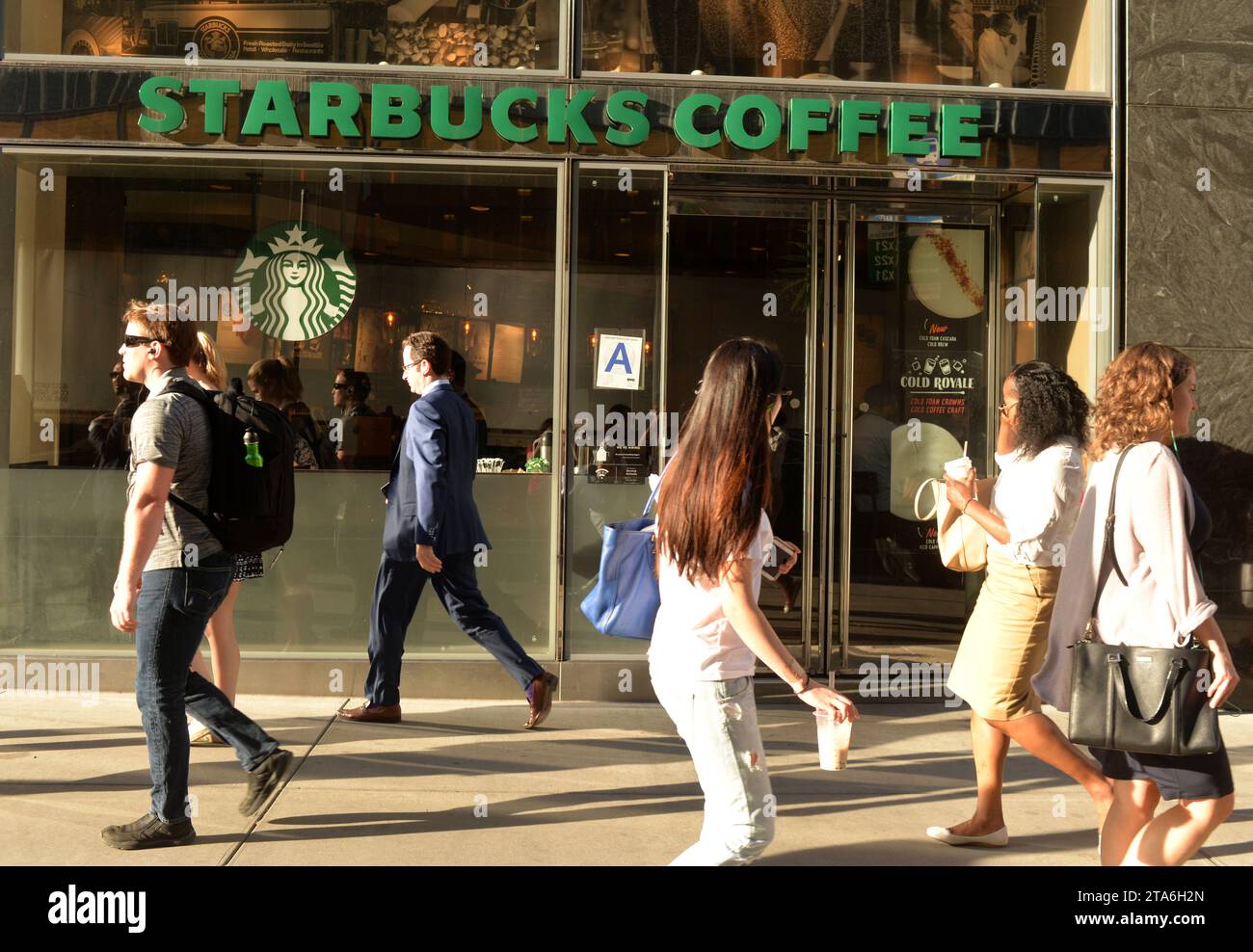 New York, USA - May 30, 2018: People on street near Starbucks Coffee in Midtown of Manhattan. Stock Photo