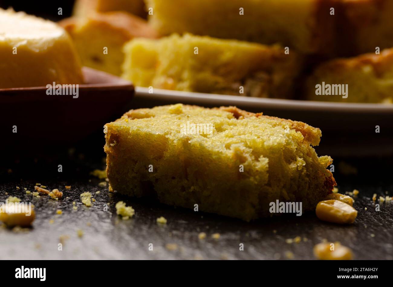 Slices of homemade cornbread and butter on kitchen table Stock Photo