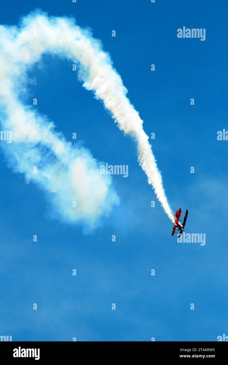 A stunt pilot performs flips and spins as he demonstrates precision flying at an air show Stock Photo