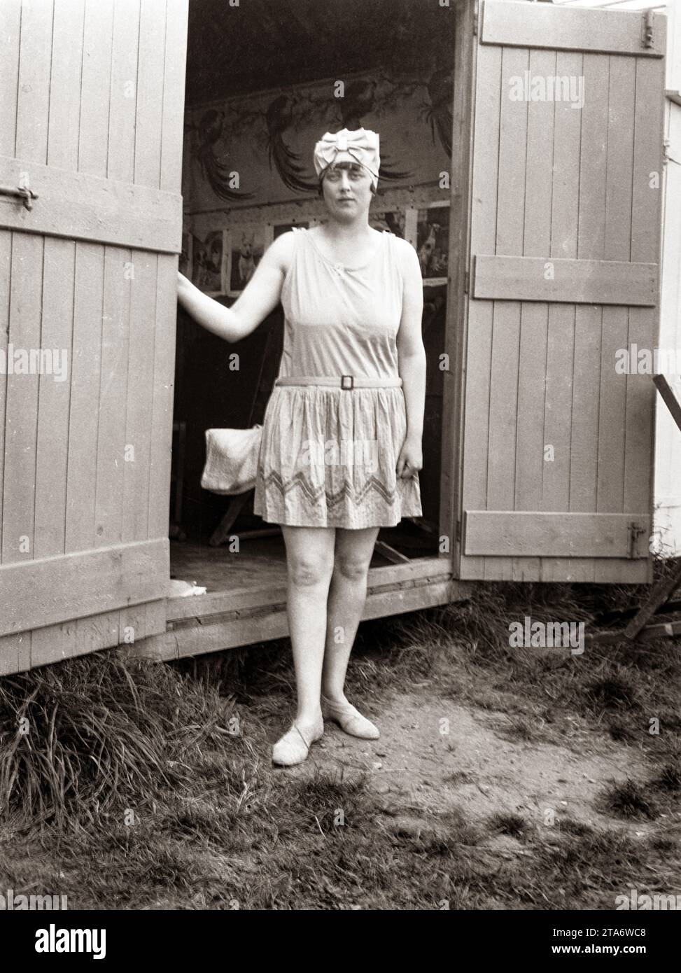 A young woman in Victorian times at the entrance to her beach changing room or beach hut in the 1890s Stock Photo