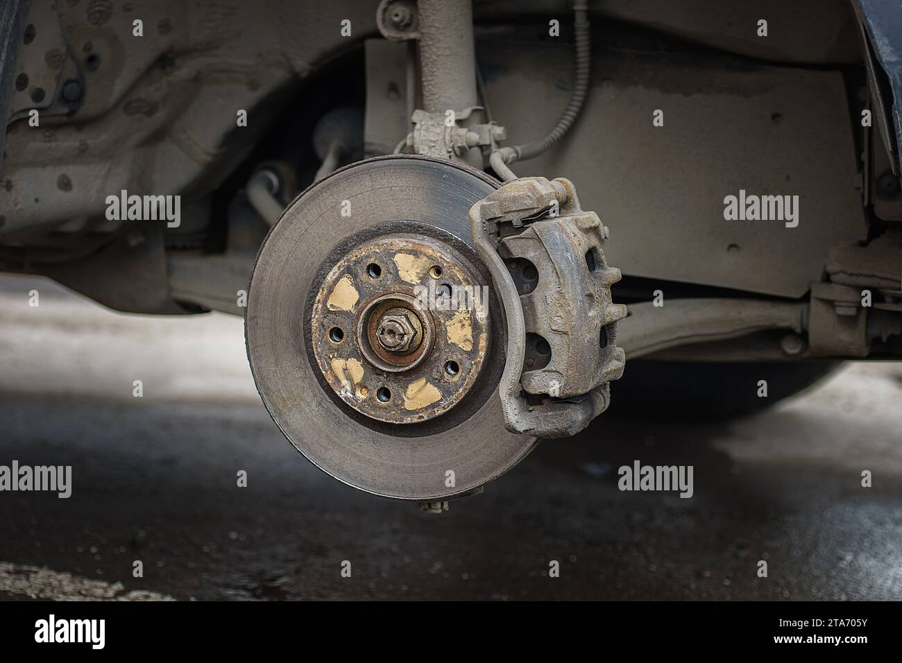 Old and rusty car's suspension parts. Rusted disc brake and caliper on