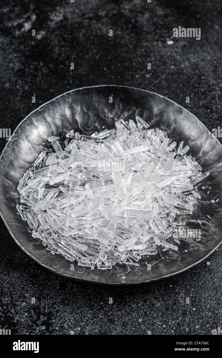 Menthol Crystals in a steel small plate. Black background. Top view. Stock Photo