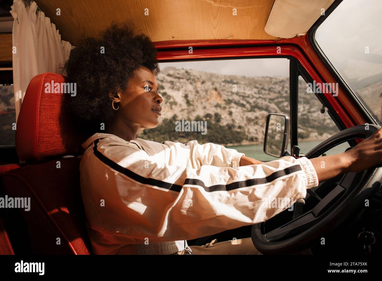 Thoughtful young woman driving van during road trip Stock Photo