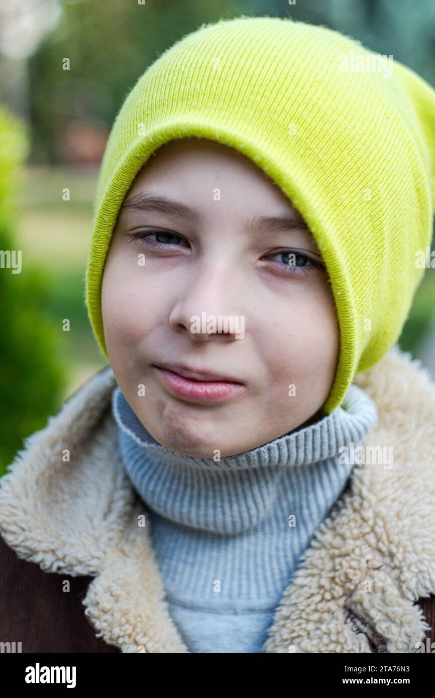 Close-up portrait of a boy in warm clothing standing in a park in autumn, Georgia Stock Photo