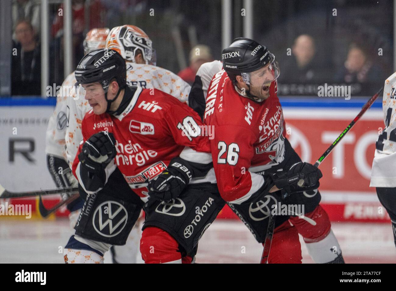 28.11.2023, Lanxess-Arena, Koeln, GER, DEL, Koelner Haie vs Grizzlys Wolfsburg, 22.Spieltag, Saison 2023/24, Im Bild: David McIntyre (Kölner Haie, #26) wird von Justin Feser (Grizzlys Wolfsburg, #71) hart attackiert im Zweikampf, Duell, Dynamik, Aktion, Action, Spielszene; Gestik, Mimik, Emotionen; Schmerz Justin Schuetz (Kölner Haie, #10) versucht zu klären Foto © nordphoto GmbH/Denkinger Stock Photo