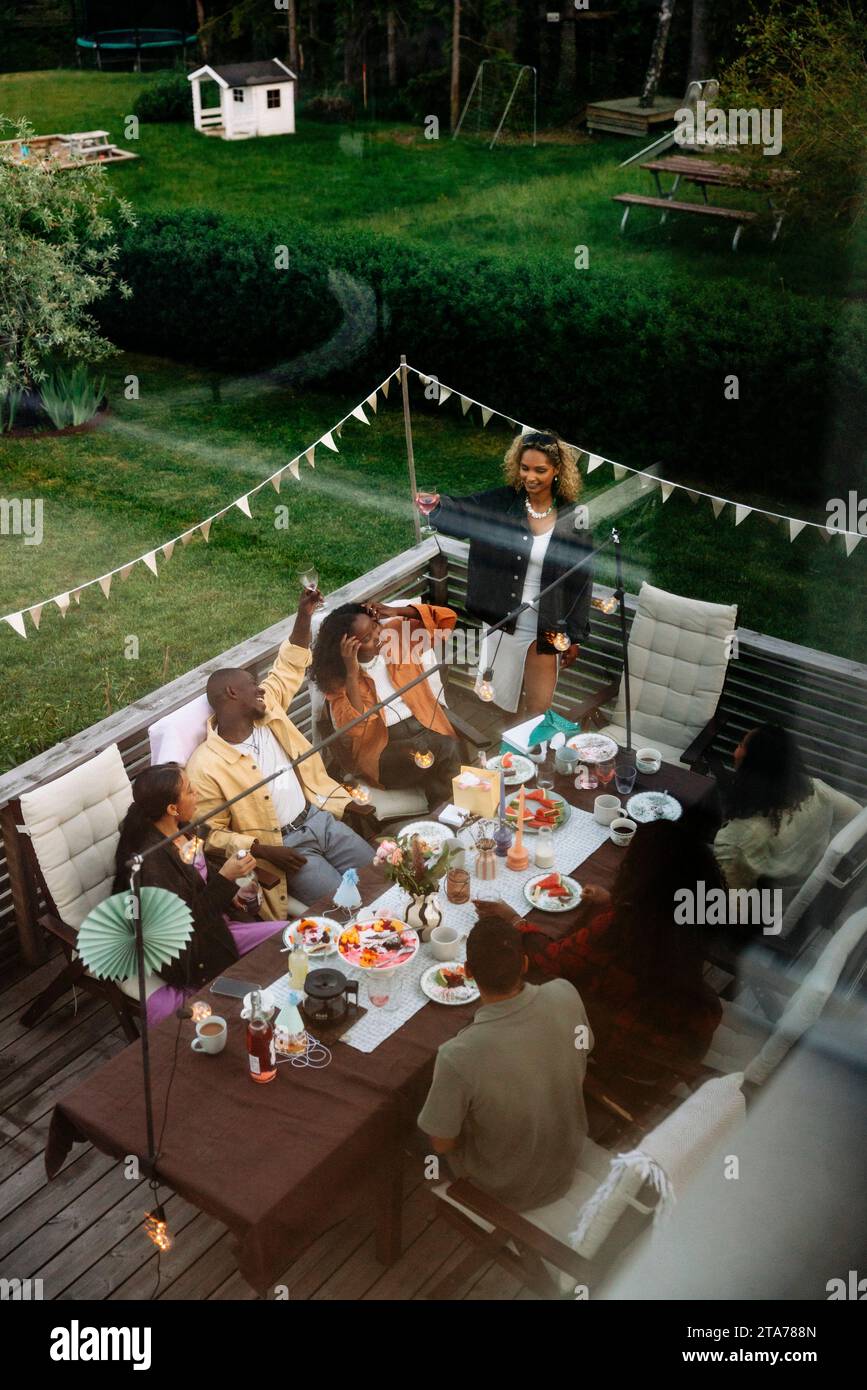 High angle view of male and female friends enjoying dinner party in back yard Stock Photo
