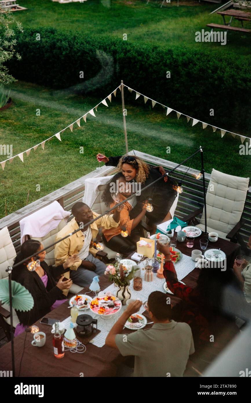 Male and female friends having fun during dinner party in back yard Stock Photo