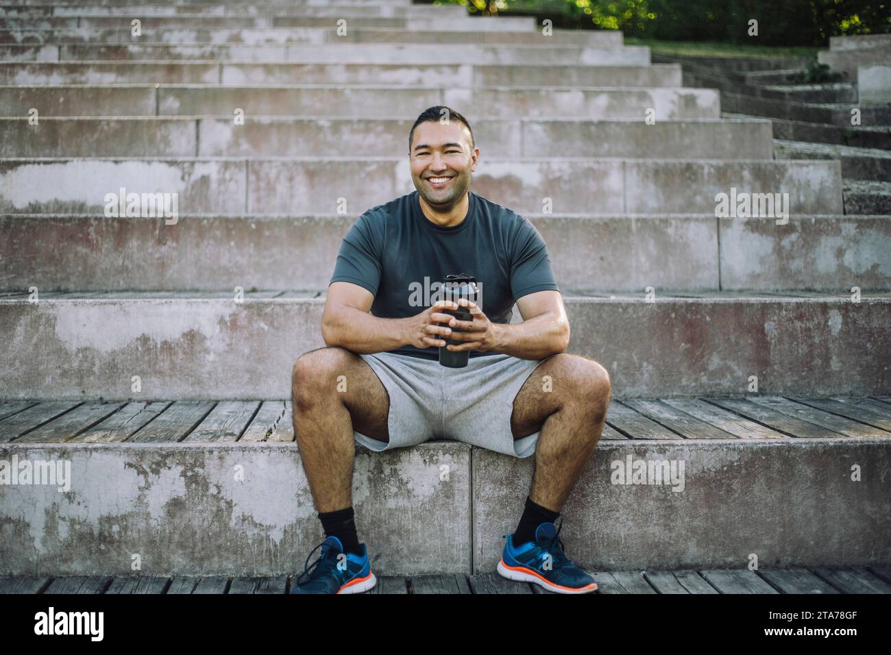 Portrait of smiling man sitting on steps Stock Photo