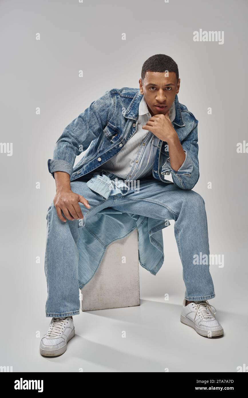 good looking african american male model in denim outfit sitting on