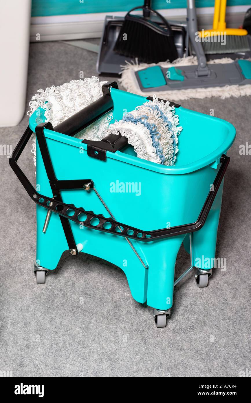 Professional turquoise bucket on wheels with a rag wringing system for