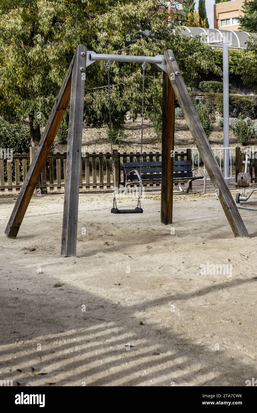 An urban playground with swings, slides and other games on a sandy floor Stock Photo