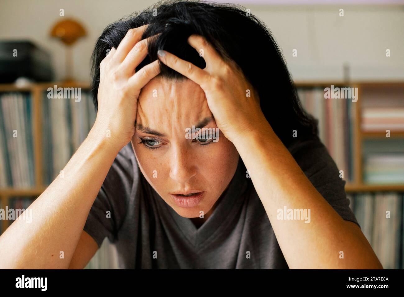 Stressed woman with head in hands at home Stock Photo