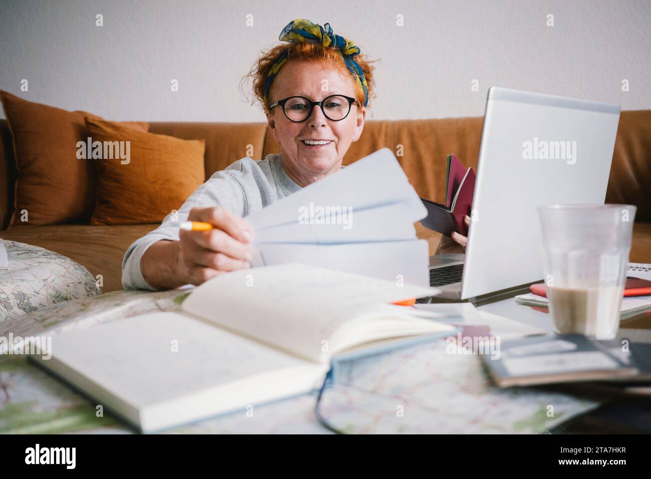 Happy senior woman holding tickets while planning trip Stock Photo
