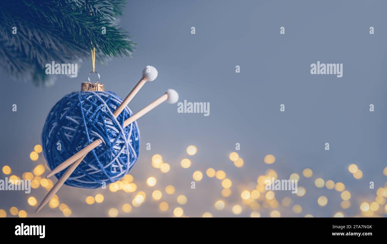 blue Christmas ball in the form of a ball of threads with spokes on the Christmas tree. needlework. with copy space Stock Photo