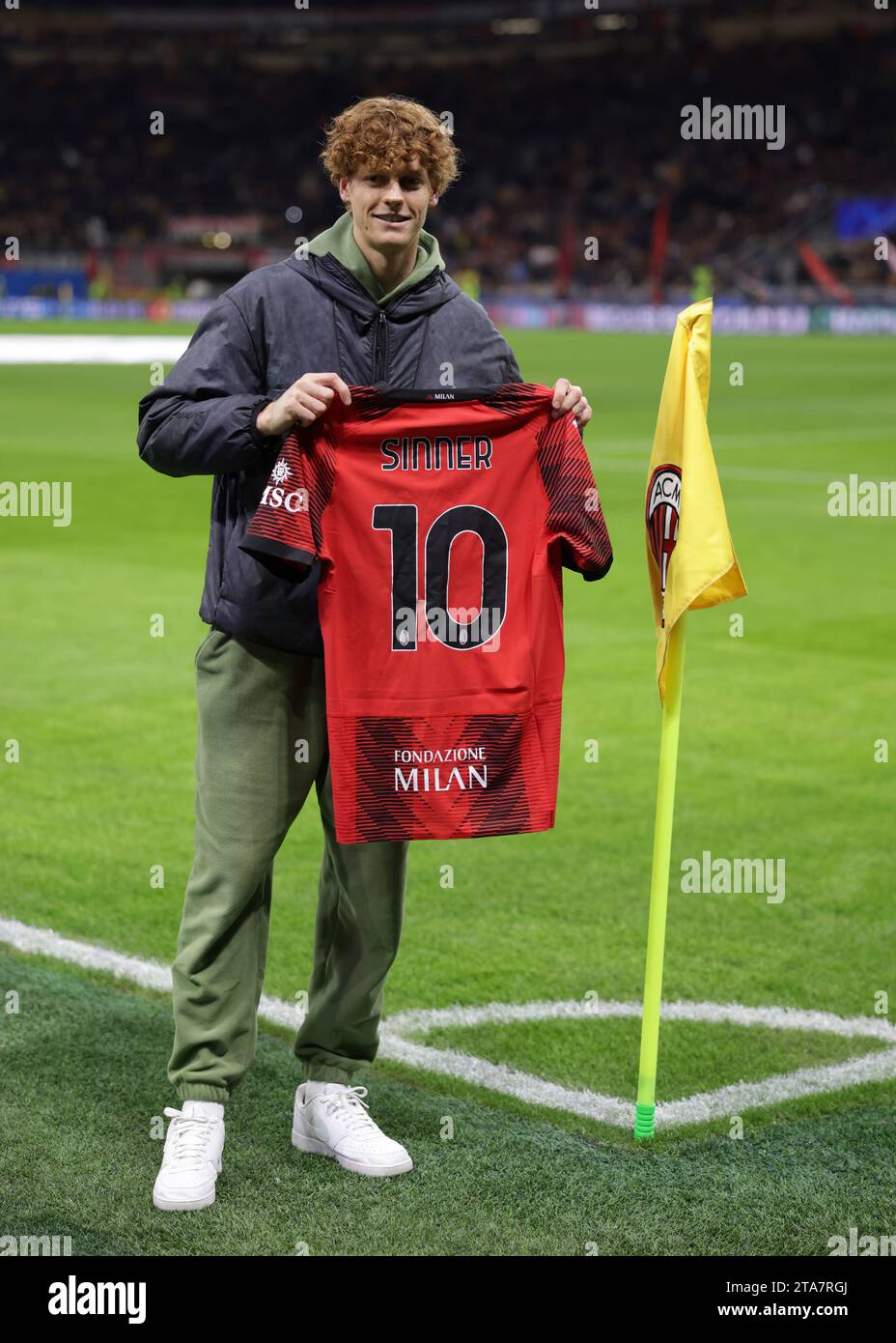 Milan, Italy. 28th Nov, 2023. Italian Tennis player and Winner of the 2023 Davis Cup, Jannick Sinner poses with an AC Milan jersey at the corner flag prior to the UEFA Champions League match at Giuseppe Meazza, Milan. Picture credit should read: Jonathan Moscrop/Sportimage Credit: Sportimage Ltd/Alamy Live News Stock Photo