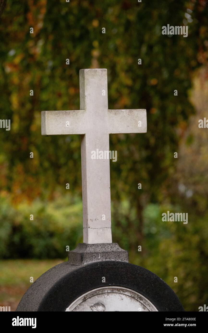 Simple white generic christian stone cross in a cemetery. Stock Photo