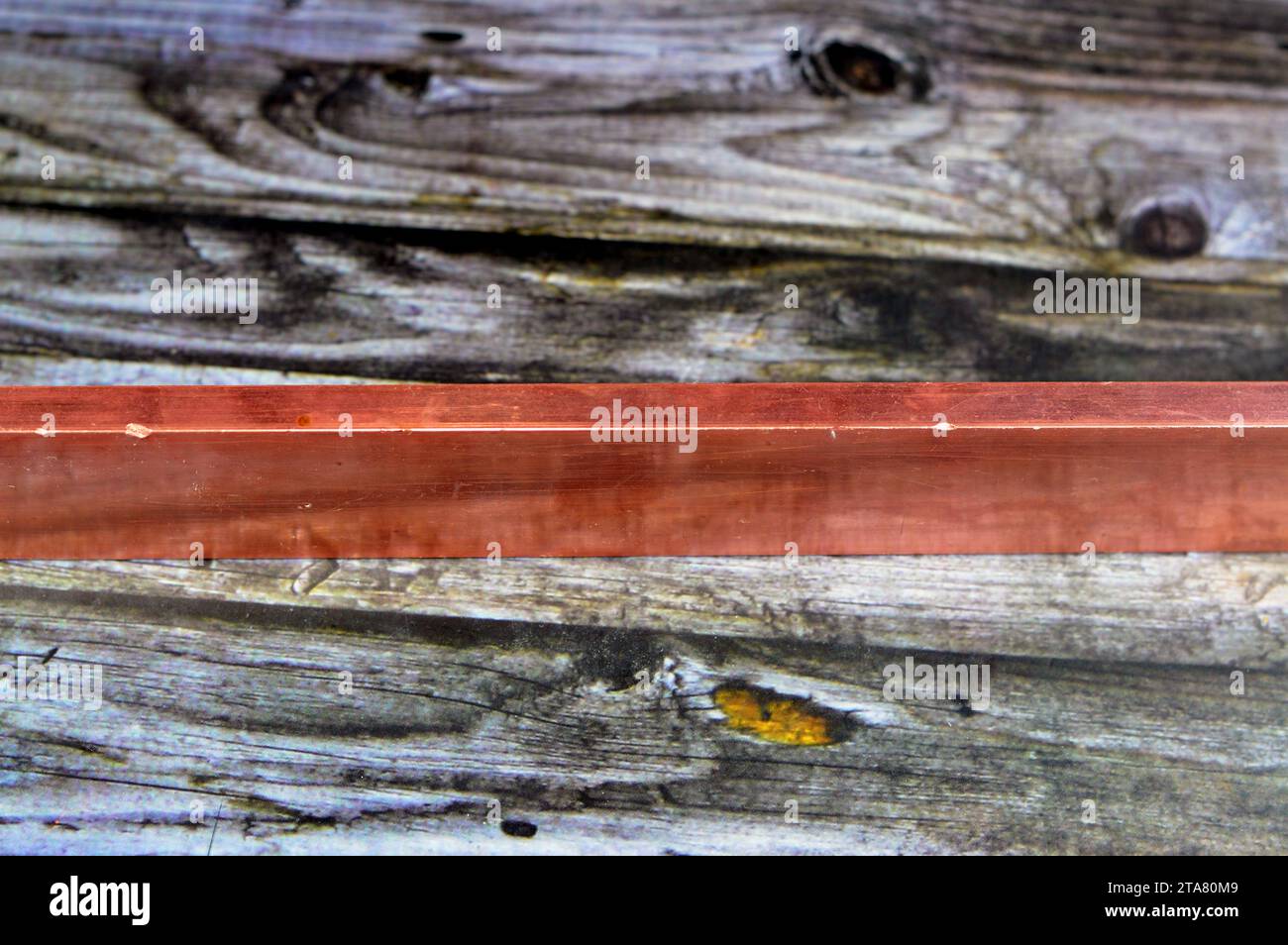 Long heavy copper bar, Copper is a mineral, an element and a metal, used in wiring, roofing, pipes, pots and pans, decorations and artworks, jewelry a Stock Photo